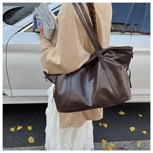 Detail of dark brown vintage oil wax leather tote bag with adjustable shoulder strap