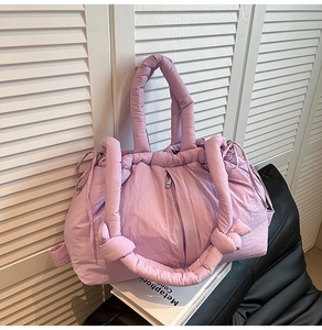 Close-up of a lavender quilted puffer tote bag with knotted strap details and puffy texture