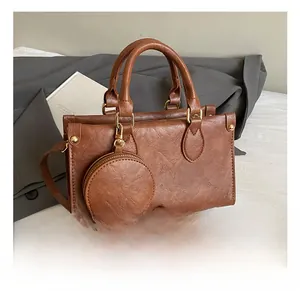 Detailed shot of a brown textured faux leather handbag with a round coin purse attachment