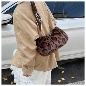 Détail du sac baguette en fausse fourrure léopard avec chaîne argentée porté par un modèle