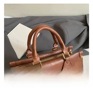 Detail of retro brown leather bag with golden hardware and circular coin purse attachment