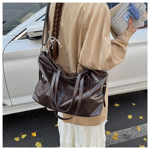 Macro detail of large brown tote bag with leather texture and drawstring on a car background