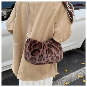 Detailed back view of leopard print plush bag with silver chain strap on model shoulder