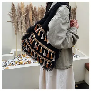 Close-up of knit tote bag featuring multi-colored tassels and golden embroidery details
