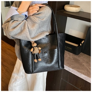 Large black faux leather tote bag with a cute rabbit charm shown on a model