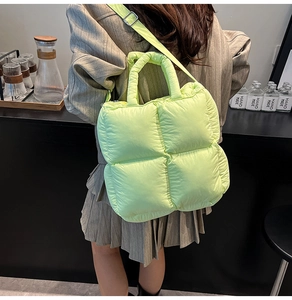 Quilted lime green puffer tote bag shown on model with shoulder strap and cloud texture
