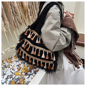 Detail of bohemian knit tote bag featuring multi-color tassels and cozy velvet texture