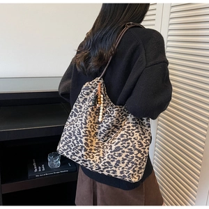 Detail of leopard print tote bag with beaded pendant and slim shoulder straps