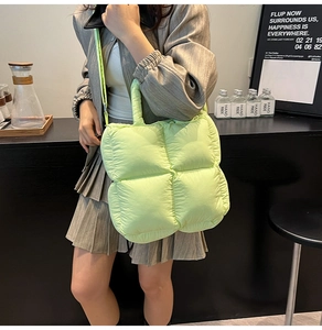 Detail of light green quilted puffy tote bag with top handle and adjustable strap