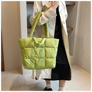 Detail of lime green quilted tote bag with fashion tag and soft padded down texture