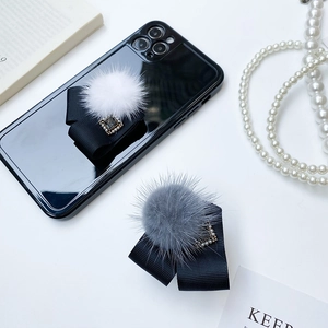 Détail du support téléphone en fourrure avec ruban noir et cristal carré étincelant