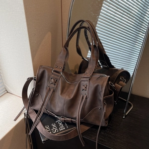 Vintage dark brown large tote bag with rivet studs and lace-up design in a mirror setting