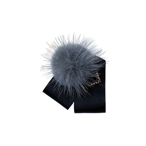 Détail de pince à cheveux en fourrure grise avec ruban noir et perles élégantes