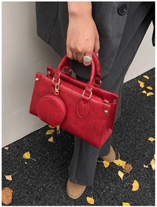 Detail of red square crossbody bag with mini round coin purse and gold hardware accents
