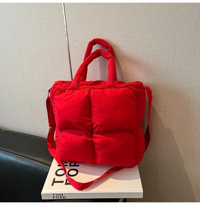 Detailed close-up of bright red quilted puffer tote with lightweight padded texture