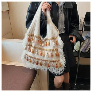 Detail shot of bohemian knit tote bag with gradient tassels and sequin trim accents