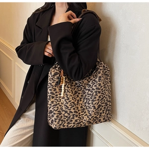 Detail view of large leopard print tote bag with drawstring and wooden bead tassel decor