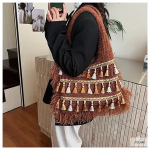 Close-up of caramel knit tote bag with boho tassels and shimmering gold sequin accents