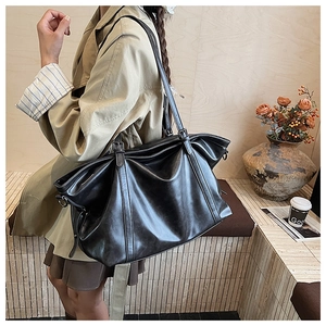 Gros plan du grand sac cabas noir en cuir avec boucle en métal et texture souple