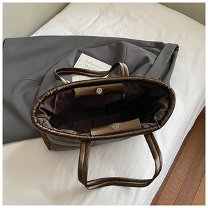 Quilted bronze down fabric tote bag with spacious interior and magnetic closure