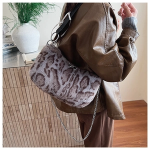 Detailed view of leopard print plush shoulder bag with silver chain and wide leather strap