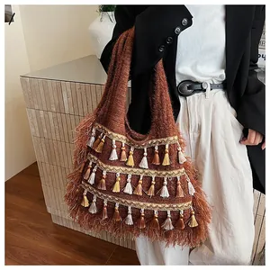 Detail of bohemian brown knit shoulder bag featuring colorful tassel fringe accents