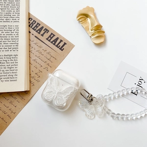 Detail of transparent AirPods case with white lace butterfly embroidery and bead strap