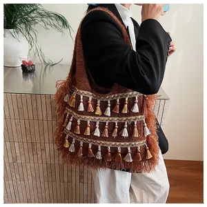 Close-up of a brown knit tote bag featuring retro fringe tassels and bohemian woven texture
