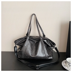 Macro detail of dark grey faux leather tote bag showing vintage marble texture and strap