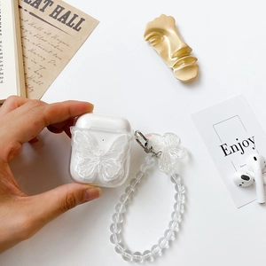 Detailed view of clear AirPods case with delicate white lace bow and beaded pearl bracelet