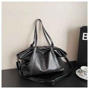 Close-up of retro distressed leather texture and zipper detail on oversized tote bag