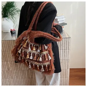 Close-up of bohemian knit tote bag with layered fringe tassels and plush woven texture