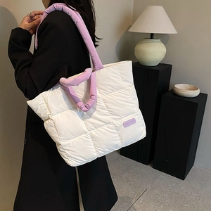Quilted white puffer tote bag with purple padded straps shown on a model