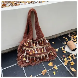 Close-up of bohemian brown knit tote bag with layered colorful tassels and fringe detail