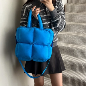 Quilted blue puffer handbag with padded squares and crossbody strap for women