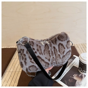 Detail of leopard print faux fur hobo bag with wide leather strap and silver hardware