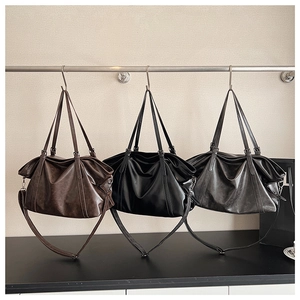Three oversized vintage tote bags in dark brown, black, and charcoal grey on hangers