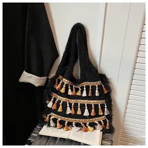 Close-up of black knit tote bag featuring multi-color bohemian fringe and plush texture