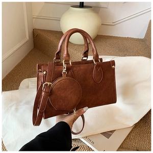 Detail of caramel brown faux leather square handbag with litchi texture and gold hardware