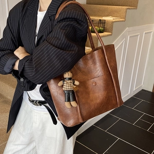 Deep brown leather tote bag for women with a cute bear pendant on a shoulder strap