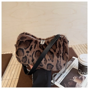 Close-up of leopard print plush hobo bag featuring dual zippers and silver chain detail