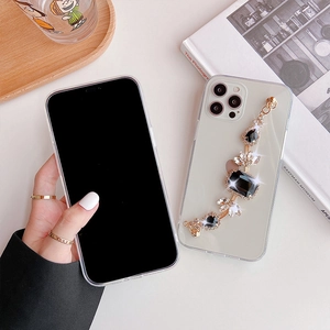 Dettaglio custodia trasparente per iPhone con catena di gemme nere e finiture dorate