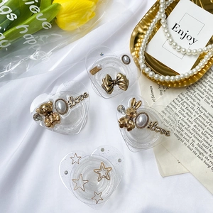 Detailed view of 4 heart-shaped glitter phone grips with pearls and gold charms