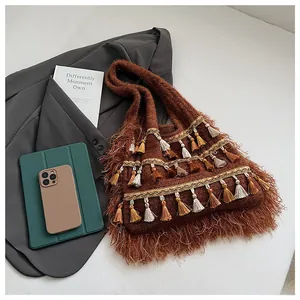 Detailed close-up of brown knit tote with multi-colored fringe and faux fur edge
