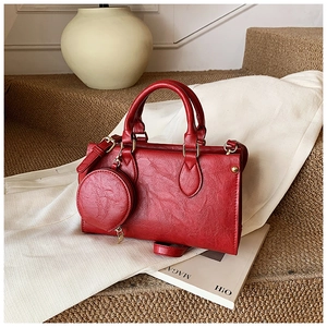 Detail of red leather Boston bag with matching circular coin purse and gold hardware