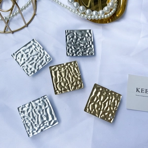 Detail of square hammered metal phone grips with sparkling rhinestones in gold and silver