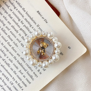 Detail of cute golden bear phone grip with sparkling rhinestones and white pearls