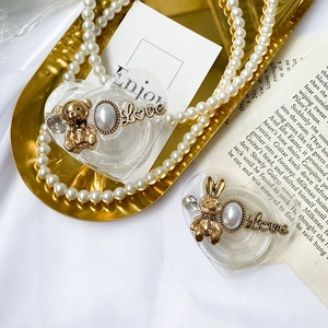 Macro shot of heart-shaped phone grips with gold bunny and pearl details on a tray