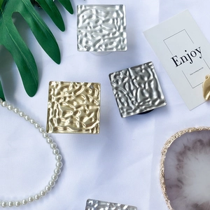 Close-up of square hammered metal phone grips in gold and silver with rhinestones