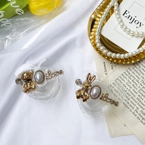 Detail of heart-shaped phone stands with 3D bear, rabbit charms and pearl accents